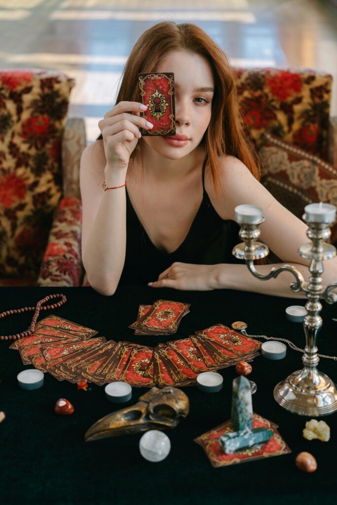 Tirada de tarot sobre paño negro con velas y cristales